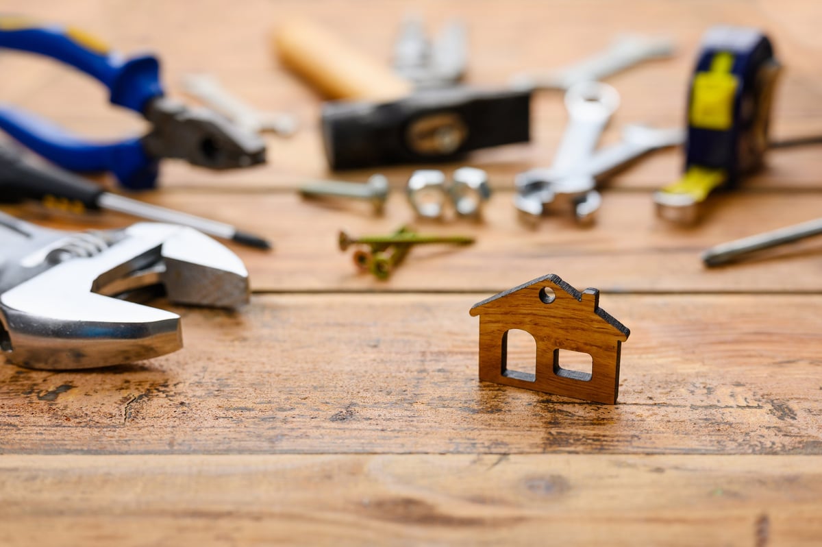 House model and tools on a workbench representing local property services