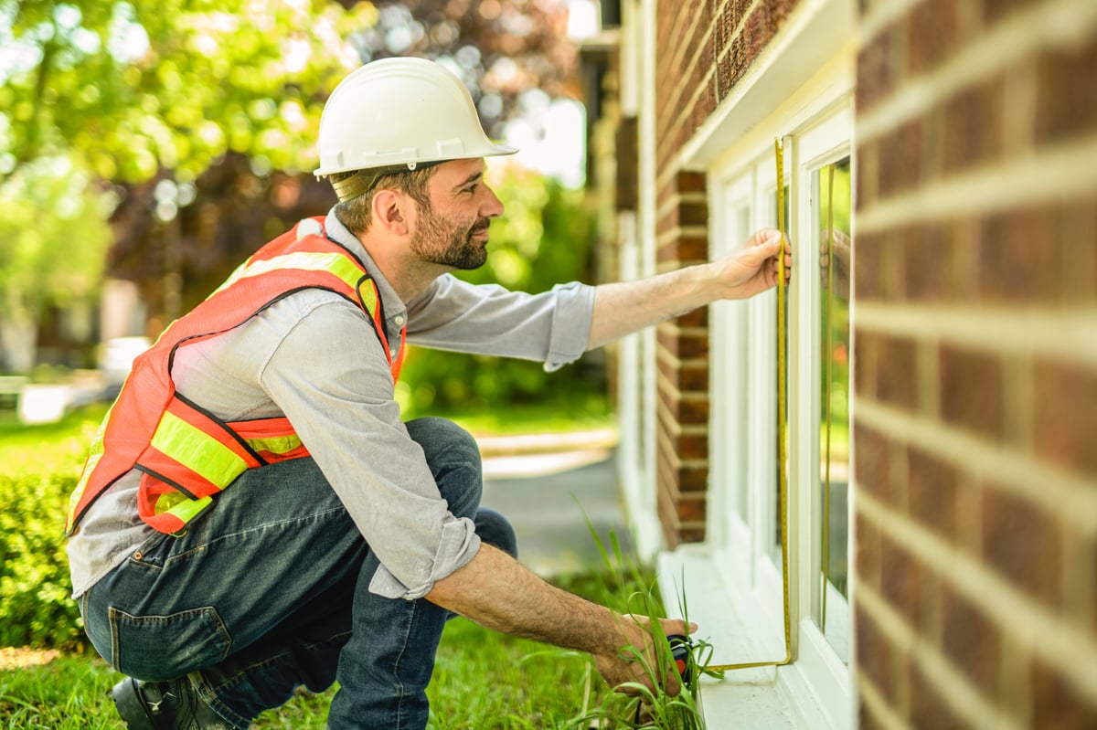 Contractor inspecting a newly renovated house exterior
